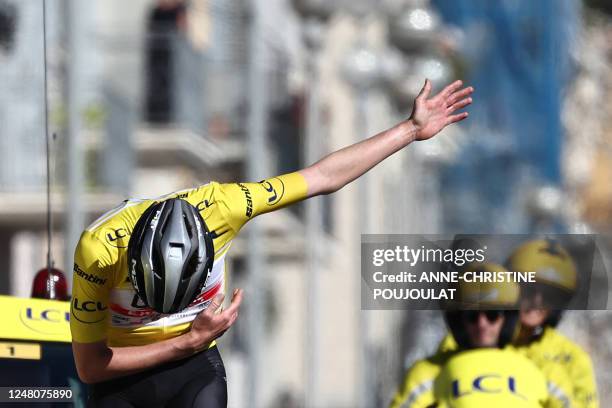 Team Emirates' Slovenian rider Tadej Pogacar wearing the overall leader's yellow jersey celebrates as he crosses the finish line of the 8th and final...