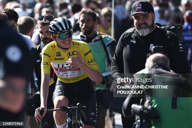 Team Emirates' Slovenian rider Tadej Pogacar wearing the overall leader's yellow jersey gestures as he celebrates after winning the 8th and final...