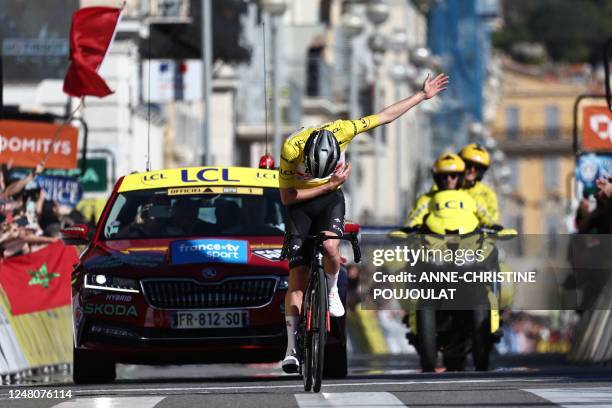 Team Emirates' Slovenian rider Tadej Pogacar wearing the overall leader's yellow jersey celebrates as he crosses the finish line to win the 8th and...