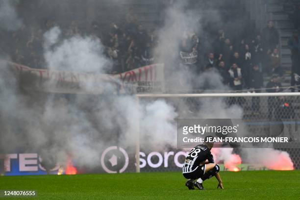 Angers' Algerian forward Farid El Melali looks on as Angers' supporters like red flares during the French L1 football match between SCO Angers and...
