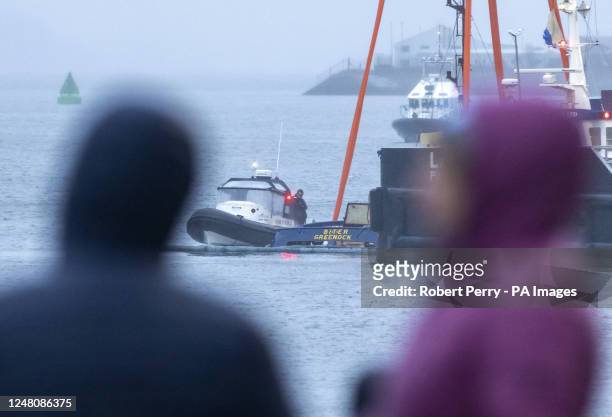 Salvage teams at Victoria Harbour recover a tugboat from the water in the Firth of Clyde near Greenock where two men died after it sank at the Custom...