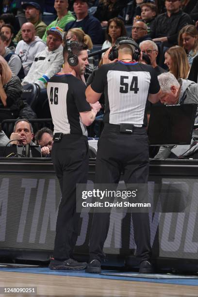 Ben Taylor and Ray Acosta check the score moniter during the game on February 24, 2023 at Target Center in Minneapolis, Minnesota. NOTE TO USER: User...