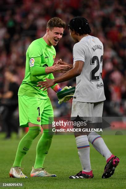Barcelona's German goalkeeper Marc-Andre ter Stegen and Barcelona's French defender Jules Kounde celebrate victory at the end of the Spanish league...