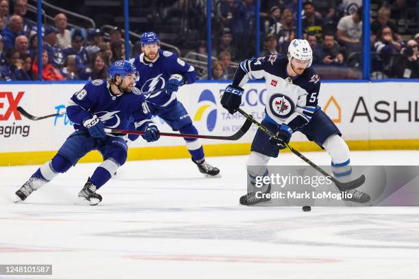 Brandon Hagel of the Tampa Bay Lightning chases against Dylan Samberg of the Winnipeg Jets during the first period at Amalie Arena on March 12, 2023...