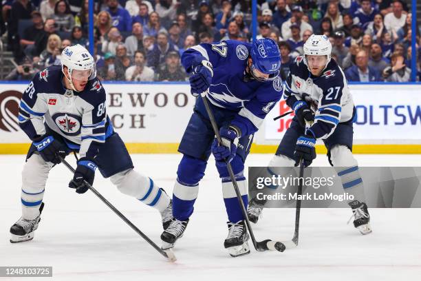 Alex Killorn of the Tampa Bay Lightning against Nate Schmidt and Nikolaj Ehlers of the Winnipeg Jets during the second period at Amalie Arena on...