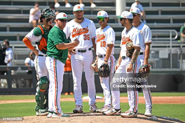 Miami head coach Gino DiMare and his infield wait for a new pitcher to enter the game in the fourth inning as the Miami Hurricanes faced the NC State...