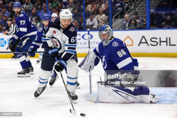Nino Niederreiter of the Winnipeg Jets reaches for a rebound in front of Andrei Vasilevskiy of the Tampa Bay Lightning during the third period of a...