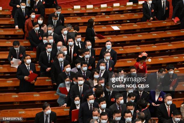 Delegates leave after the closing session of the National People's Congress at the Great Hall of the People in Beijing on March 13, 2023.