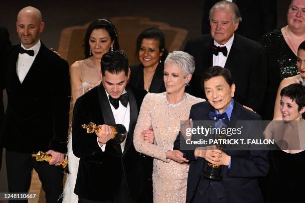Film producer Jonathan Wang accepts the Oscar for Best Picture for "Everything Everywhere All at Once" alongside US actress Jamie Lee Curtis onstage...