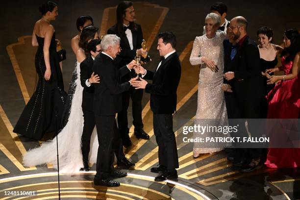 Film producer Jonathan Wang accepts the Oscar for Best Picture for "Everything Everywhere All at Once" from US actor Harrison Ford onstage during the...