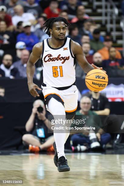 Oklahoma State Cowboys guard John-Michael Wright brings the ball up court in the first half of a Big 12 Tournament basketball game between the...