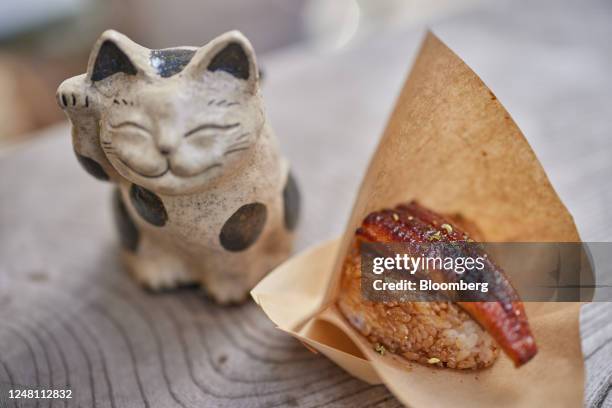 An eel rice-ball next to a manekineko figure in the Asakusa district of Tokyo, Japan, on Saturday, March 11, 2023. The Japan...