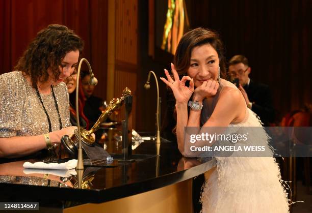 Malaysian actress Michelle Yeoh , waits as her Oscar for Best Actress in a Leading Role for "Everything Everywhere All at Once" is engraved during...