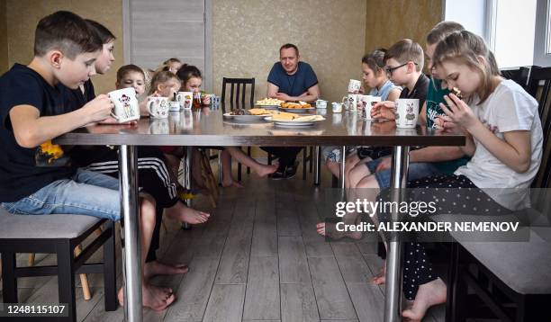 The family of Russian pastor Roman Vinogradov has a tea break in their house outside the Siberian city of Novosibirsk on March 10, 2023. - Russian...