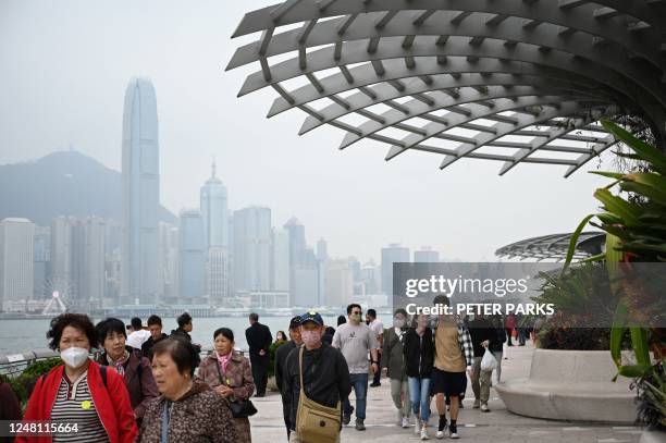 Tourists from mainland China walk along the harbour front in Hong Kong on March 13, 2023.