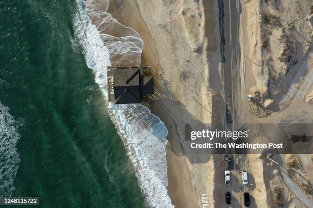 Ocean waves encroach upon a beachfront property where a portion of Highway 12 has been closed due to severely eroded coastline on the Outer Banks of...