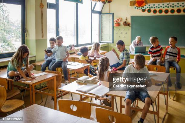 large group of elementary students having fun on a class in the classroom. - elementary school building stock pictures, royalty-free photos & images