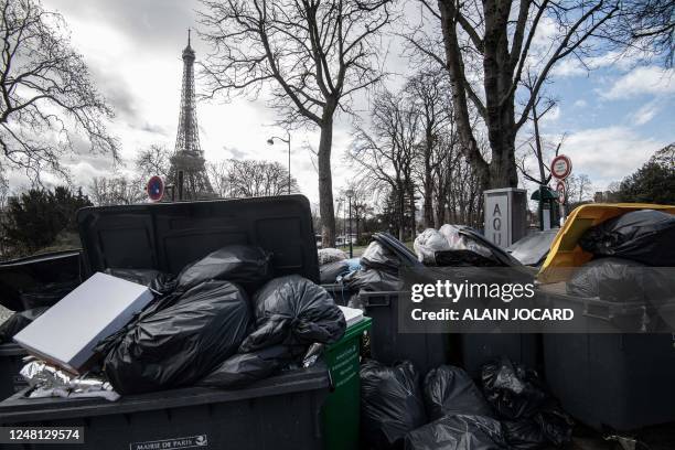 This photograph taken in Paris, on March 13 shows household waste near the Eiffel Tower that has been piling up on the pavement as waste collectors...