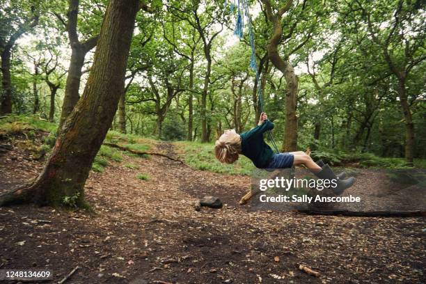 child swinging on a rope swing - rope swing stock pictures, royalty-free photos & images