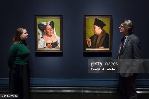 Gallery staff members look at paintings titled 'An Old Woman ' and 'An Old Man', about 1513, oil on panel by Quinten Massys during a photocall for...