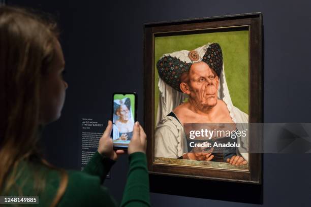 Gallery staff member takes a photo of a painting titled 'An Old Woman ' by Quinten Massys during a photocall for The Ugly Duchess: Beauty and Satire...