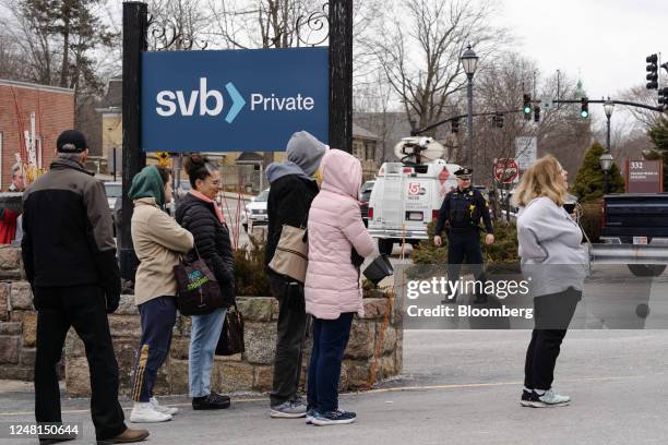 Customers wait in line outside of a Silicon Valley Bank branch in Wellesley, Massachusetts, US, on Monday, March 13, 2023. The collapse of Silicon...