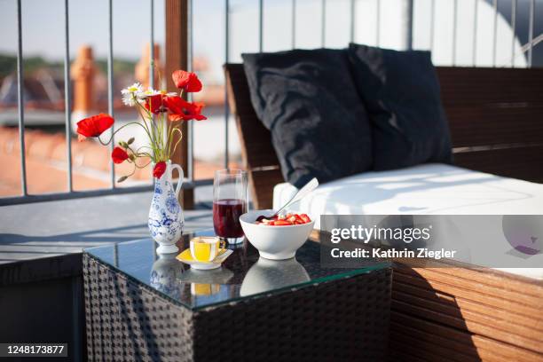 healthy breakfast on a side table next to daybed outside - poppies in vase stock pictures, royalty-free photos & images