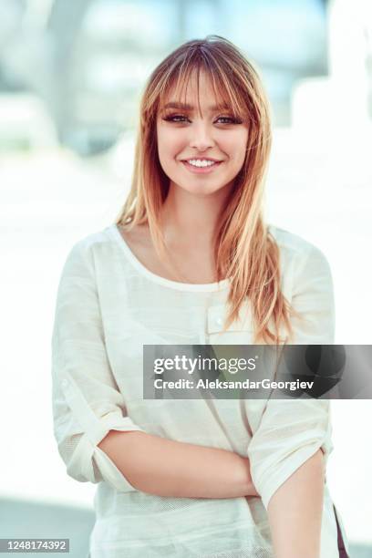 lächelnde weibliche in leinen shirt stehen draußen - bangs stock-fotos und bilder