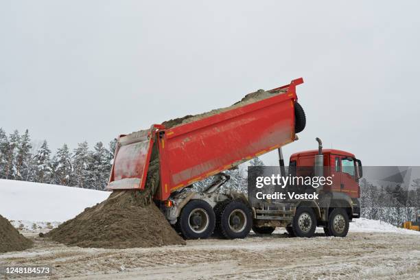 construction of a new road in siberia - camión de descarga fotografías e imágenes de stock