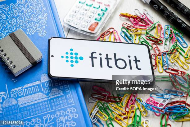 In this photo illustration a Fitbit logo seen displayed on a smartphone.