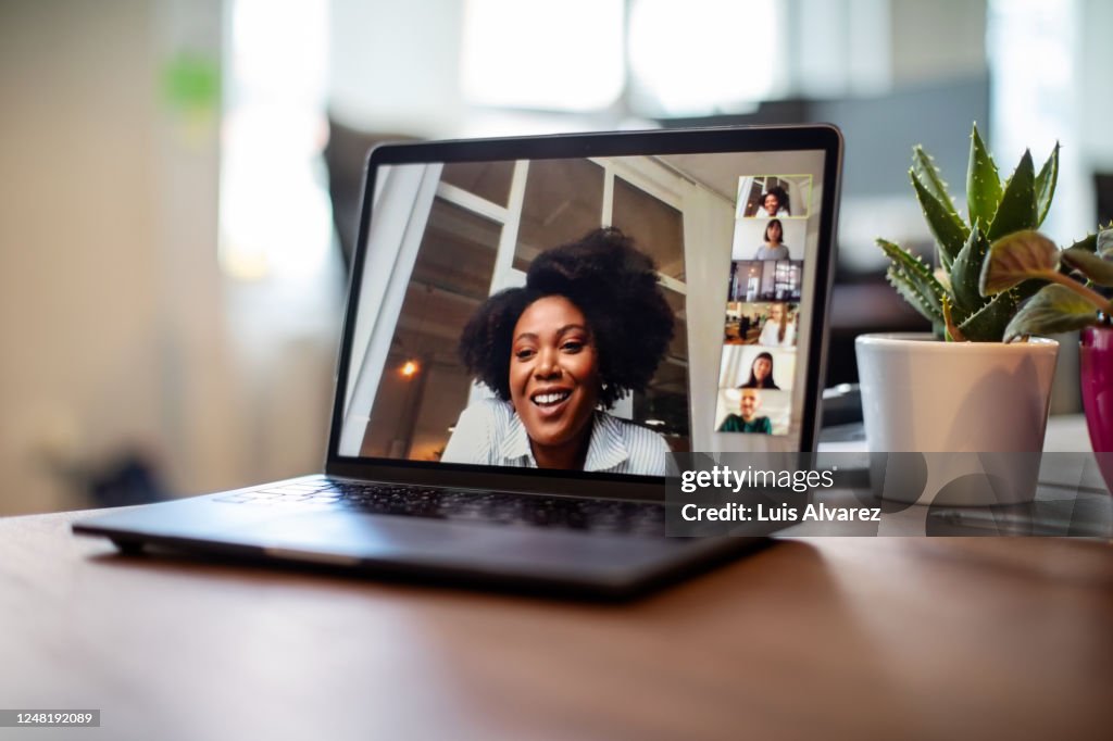 Businesswoman having a video call meeting with her team