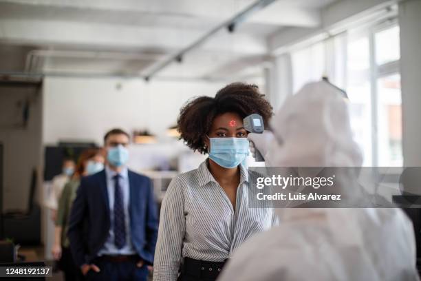 temperature checkup in office before going to the desk - pandemic reopening stock pictures, royalty-free photos & images