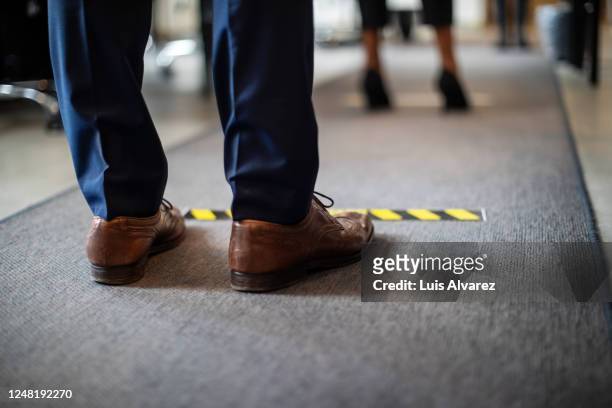 man in queue at office for safe entry checks - social distancing stockfoto's en -beelden
