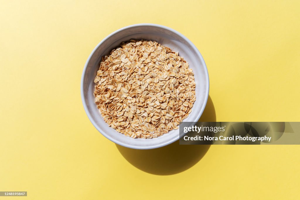 Oat Flakes in a Bowl Yellow Background
