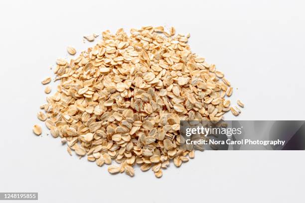 heaps of oat flake on white background - hafer stock-fotos und bilder