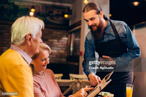 pareja madura eligiendo qué pedir para la cena - pedir matrimonio fotografías e imágenes de stock