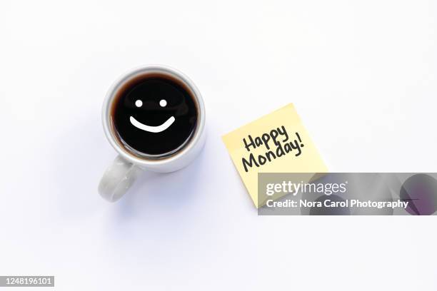 happy monday text on paper note and cup of black coffee - monday stock-fotos und bilder