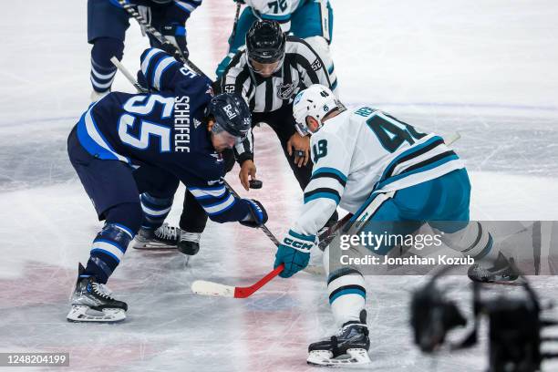 Mark Scheifele of the Winnipeg Jets and Tomas Hertl of the San Jose Sharks take a face-off in the overtime period at Canada Life Centre on March 06,...