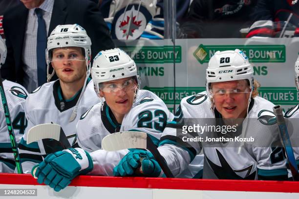 Steven Lorentz, Oskar Lindblom, and Fabian Zetterlund of the San Jose Sharks look on from the bench prior to NHL action against the Winnipeg Jets at...