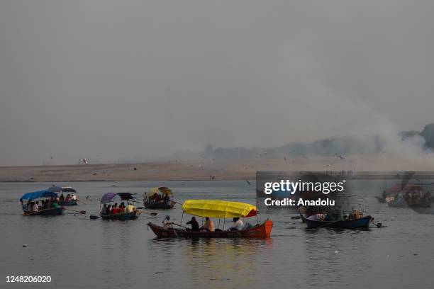 Indian tourists take a boat ride at the Sangam, the confluence of rivers Ganga, Yamuna, and mythical Saraswati, ahead of International Day of Action...
