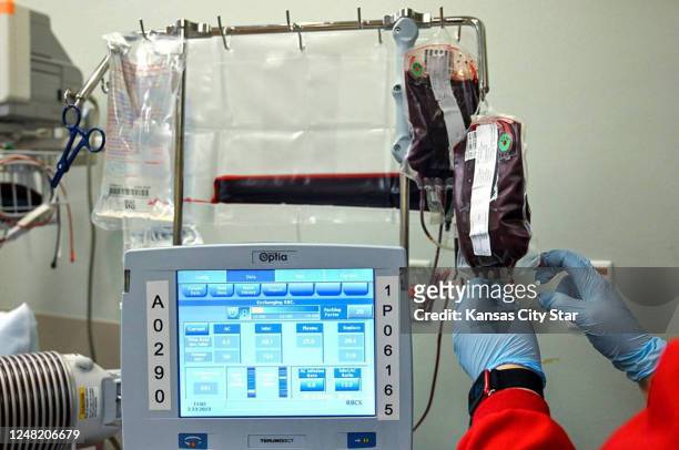 Worker from the Community Blood Center hangs a bag of blood during a transfusion for Kevin Wake at the Sickle Cell Center at University Health.