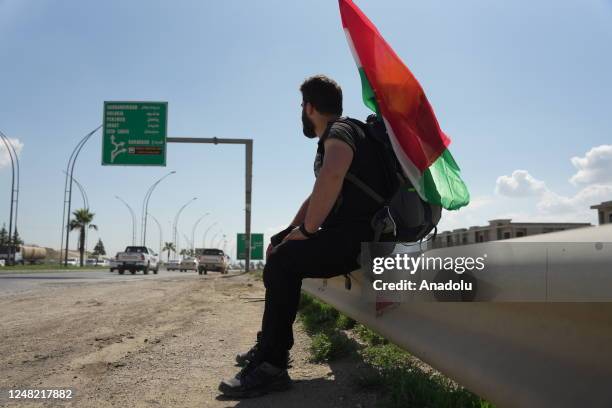 Year-old Iraqi Aram Kovli, departing from Duhok, looks at the traffic sign on the road to Halabja in Sulaymaniyah, Iraq on March 13, 2023. He is...