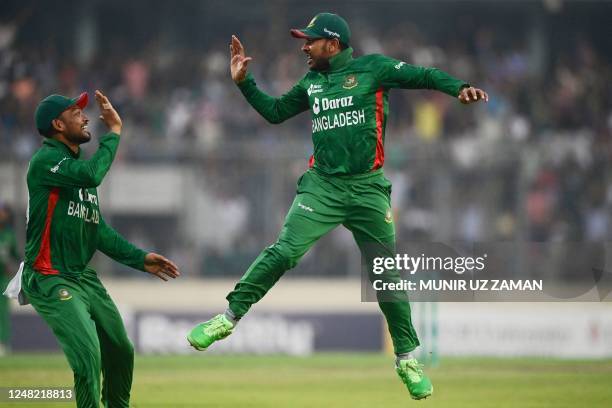 Bangladesh's Mehidy Hasan Miraz celebrates with a teammate after the dismissal of England's captain Jos Buttler during the third and final Twenty20...