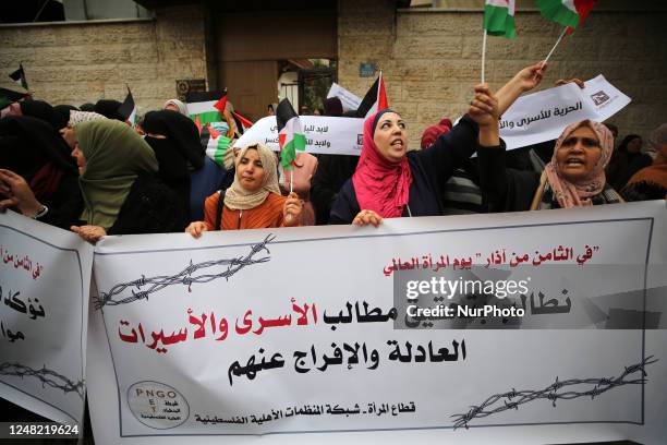 Palestinian women hold their national flag during a demonstration in support of Palestinian prisoners held in Israeli jails, some of whom are...