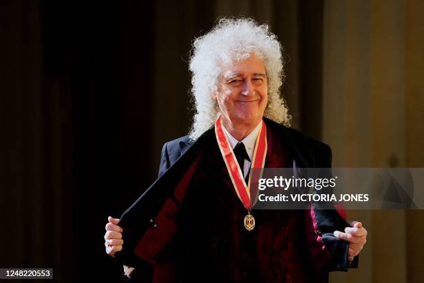 British musician Brian May poses with his medal after being appointed as a Knight Bachelor during an investiture ceremony at Buckingham Palace, in...