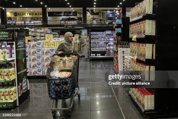 March 2023, Lebanon, Beirut: A senior woman is seen shopping at a supermarket in Beirut that is nearly empty of customers after the Lebanese pound...