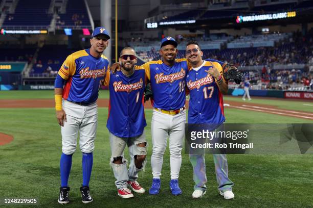 Hernán Pérez and Eduardo Escobar of Team Venezuela pose for a photo with Venezuelan music artists Mau y Ricky after the ceremonial first pitch before...