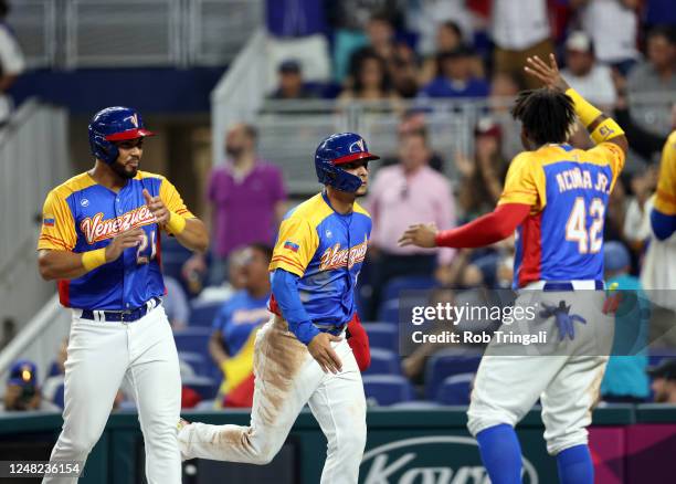 Andrés Giménez and Anthony Santander celebrate with Ronald Acuña Jr. #42 of Team Venezuela after scoring in the fourth inning of Game 7 of Pool D...