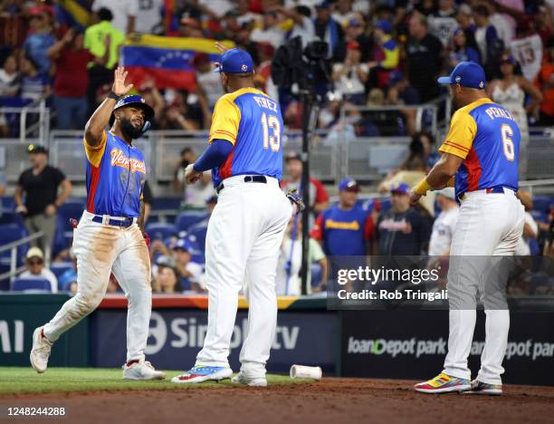Luis Rengifo of Team Venezuela celebrates with Salvador Perez after scoring in the fifth inning of Game 7 of Pool D between Team Nicaragua and Team...