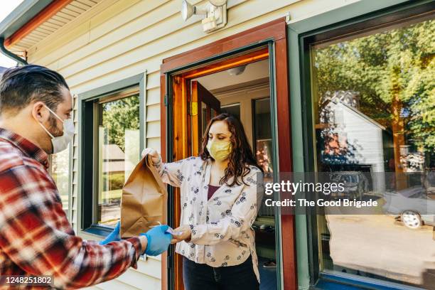 young woman receives food delivery - supply chain covid stock pictures, royalty-free photos & images
